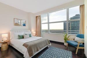 een slaapkamer met een bed en een groot raam bij Roami at Brickell Penthouse Squad Oasis in Miami