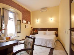 1 dormitorio con cama, escritorio y silla en Solar do Carmo Suites & Apartments, en Salvador