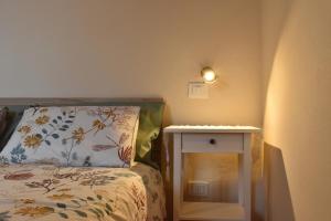 a bedroom with a bed and a side table at Claves Claustri - Camere in appartamento storico in Sarteano