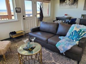 a living room with a leather couch and a table at Moonstone Beach Motel in Moclips