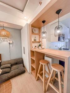 uma cozinha com um balcão e bancos num quarto em Azure North NextDoor Nest em Lagundi