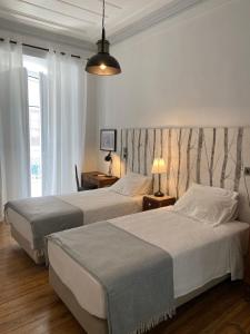 two beds in a hotel room with two lamps at União - Guest House in Tomar