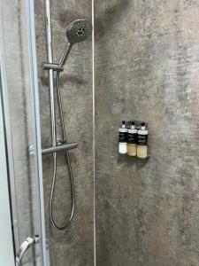 a shower with two bottles of essential oils on the wall at Tigh Stobban Apartment 1 in Fort William +28 photos