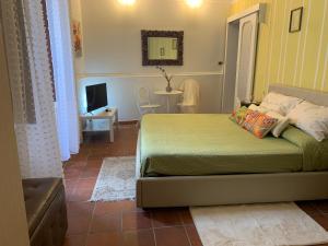 1 dormitorio con cama, mesa y TV en Casetta Lele, en Siracusa