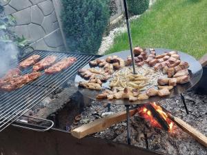 a grill with many different types of food on it at Flowers in the Center in Oradea