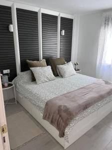 a white bedroom with a large bed with black headboards at Apartamento Casa Carmen Teguisol in Costa Teguise