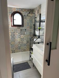 a bathroom with a sink and a mosaic wall at Apartamento Casa Carmen Teguisol in Costa Teguise