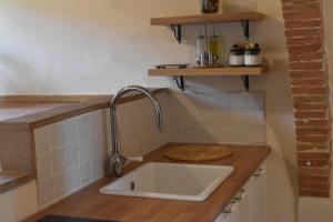uma cozinha com um lavatório e uma bancada em Claves Claustri - Camere in appartamento storico em Sarteano