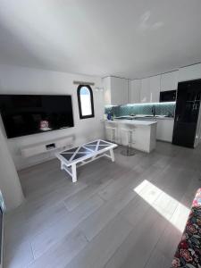 a large white kitchen with a table and a tv at Apartamento Casa Carmen Teguisol in Costa Teguise