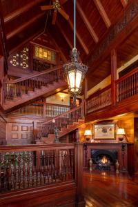 a large room with a staircase and a fireplace at Ivy Lodge in Newport