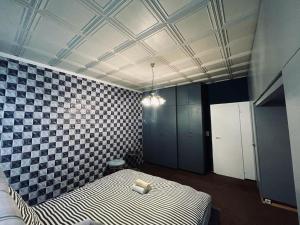 Habitación con cama y pared a cuadros en Jupiter Apartment, en Viena