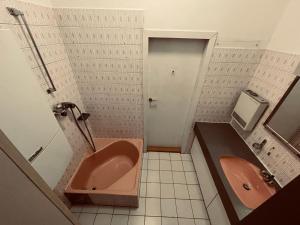 W łazience znajduje się różowa wanna i umywalka. w obiekcie Jupiter Apartment w Wiedniu