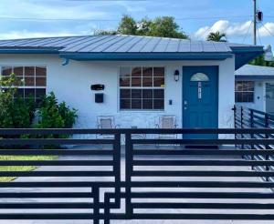 una casa blanca con una puerta azul y escaleras en Home Sweet Home Near Malls and Airport and Hwy, en South Miami