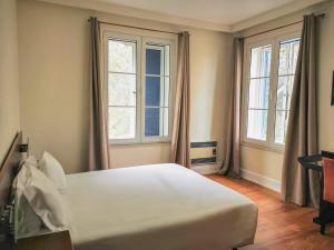 una camera da letto con un grande letto bianco e due finestre di Garden's Nest - North Villa a Conceição