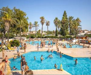 - un groupe de personnes dans la piscine d'un complexe dans l'établissement MOBIL HOME 6 pers à ST CYPRIEN 66, à Saint-Cyprien