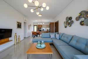 een woonkamer met een blauwe bank en een tafel bij Jason Panorama Villa 2 in Skouloúfia