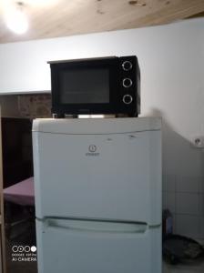 a microwave sitting on top of a refrigerator at Chambre à petit budget pour personne simple in Saint-Laurent-de-Neste