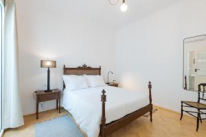 a bedroom with a bed and a lamp and a mirror at Casa Largo da Mó in Portimão