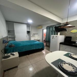 a room with a bed and a kitchen with a table at STUDIO 302 | WIFI 600MB | RESIDENCIAL JC, um lugar para ficar. in Carmo