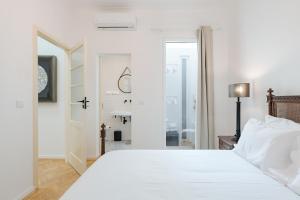 a white bedroom with a large bed and a bathroom at Casa Largo da Mó in Portimão +27 photos