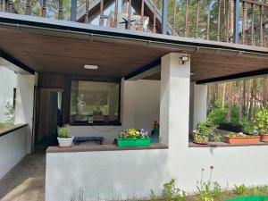 eine Veranda mit Topfpflanzen auf einem Haus in der Unterkunft Varnukroga House in Jūrmala