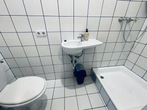 a white bathroom with a toilet and a sink at Gold Room in Vienna