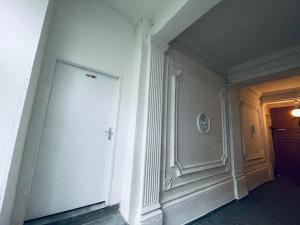 a white room with a door and a hallway at Gold Room in Vienna