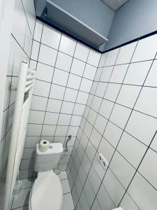 a white tiled bathroom with a toilet in it at Gold Room in Vienna