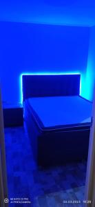 een bed in een kamer met een blauw licht bij Varnukroga House in Jūrmala