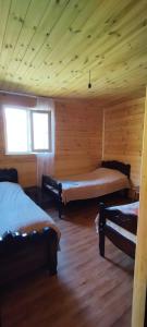 a room with two beds in a log cabin at Vila Latphari in Ushguli in Ushguli