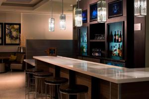a bar with stools and a counter with wine bottles at Courtyard Miami Beach South Beach in Miami Beach