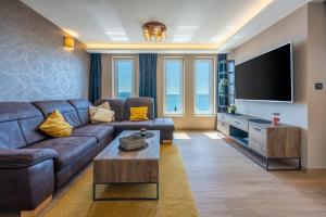 a living room with a couch and a flat screen tv at DOLLY LUX in Crikvenica