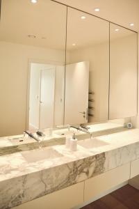 a bathroom with two sinks and a large mirror at Canary Wharf, E14 9PW, 2 Bedroom Apartment in London