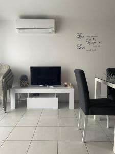 a living room with a tv and a table and chairs at Apartments Atlas Grubišić in Primošten