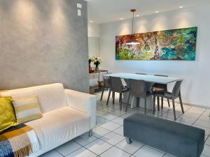 uma sala de estar com um sofá e uma mesa em Beira Mar Pajuçara com Varanda 203 - frente piscinas naturais e feira artesanato em Maceió