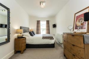 a bedroom with a bed and a mirror and a dresser at St James By the Quay in Ilfracombe