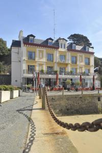 un grand bâtiment avec une chaîne en face dans l'établissement Hôtel De La Vallée, à Dinard