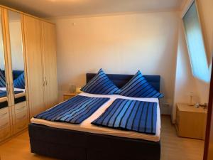 a bedroom with a blue bed with blue pillows at Ferienwohnung zum weißen Schwan in Lübeck