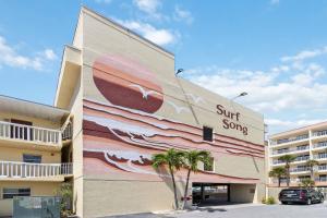 a surf song mural on the side of a building at 239 Surf Song Resort in St. Pete Beach