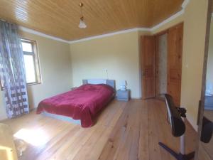 a bedroom with a bed and a wooden floor at Tsknari Oda in Oni