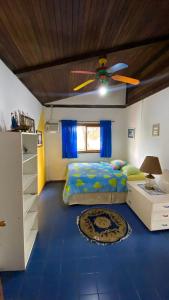 1 dormitorio con 1 cama y ventilador de techo en La Casa Del Arbol, en Olón