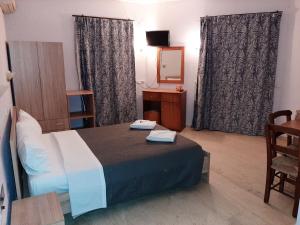 ゲオルギオポリスにあるArmonia GeoStudiosのベッドと鏡のあるホテルの部屋