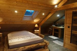 um quarto com uma cama num chalé de madeira em Le chamois, chez le charpentier d'antan, au calme, spacieux T3 duplex, ambiance chalet, vue dégagée, parking privé em Épagny