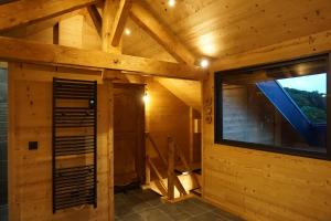 a log cabin with a large window in the room at Le chamois, chez le charpentier d'antan, La chaleur du bois, le calme de la campagne in Épagny