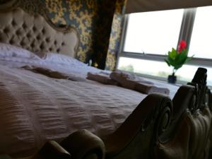a bedroom with a white bed with a flower in a window at Ultra Deluxe Versace Apartment Near Sheffield FULL SKY TV in Rotherham