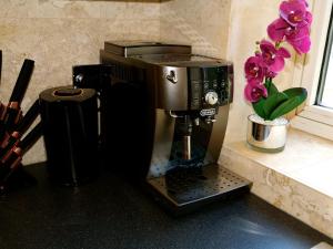 a coffee maker sitting on a counter in a kitchen at Ultra Deluxe Versace Apartment Near Sheffield FULL SKY TV in Rotherham