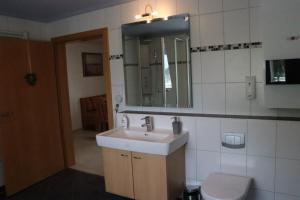 a bathroom with a sink and a toilet and a mirror at Ferienwohnung zum weißen Schwan in Lübeck