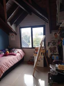 Habitación pequeña con cama y ventana en ALOHA casa soñada en la montaña en San Martín de los Andes