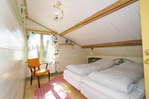 1 dormitorio pequeño con 1 cama y 1 silla en Mittjas Vallen Timber Lodge & Cabins, en Edsbyn