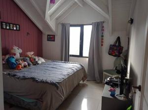 un dormitorio con una cama con animales de peluche en ALOHA casa soñada en la montaña en San Martín de los Andes